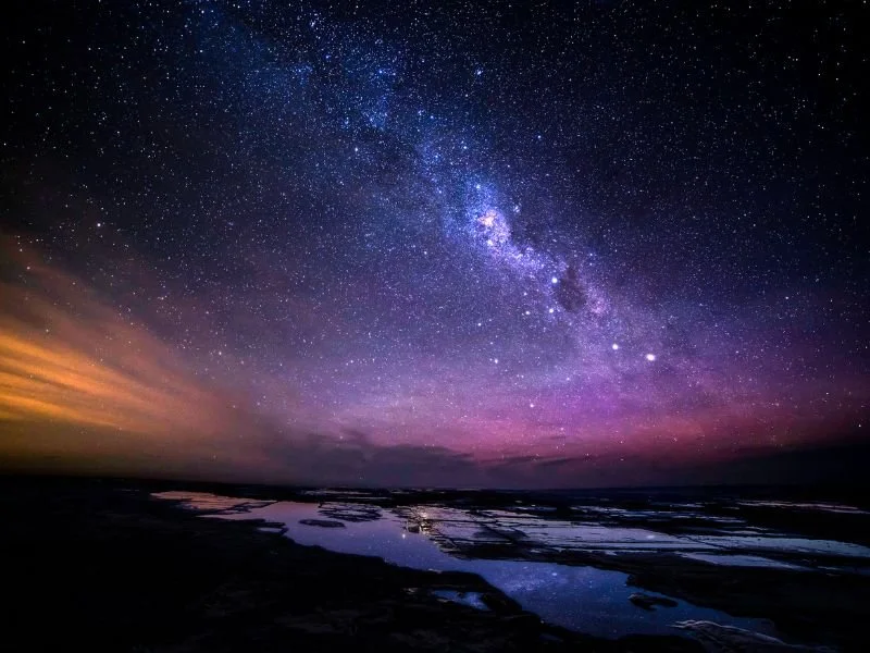 Starry night sky over the ocean
